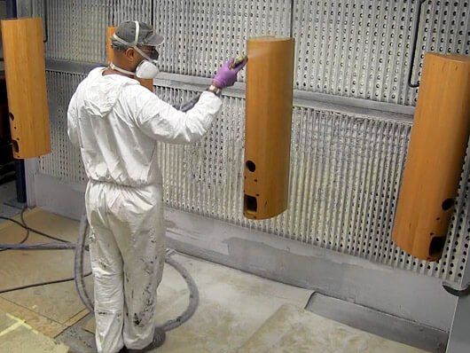Overhead conveyors handle wood furniture items through paint finishing processes