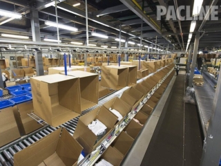 Delivering empty cartons on overhead conveyor to order pickers.