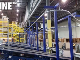 Empty box enclosed track overhead conveyor integrated with equipment.