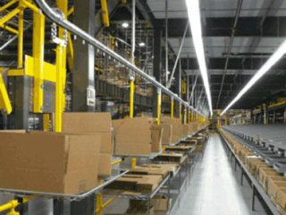 Cartons are formed and placed on wire mesh trays to be delivered to order pickers using a PACLINE conveyor.