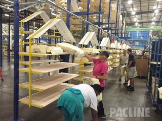 Automotive seat pads are loaded by the operators, onto the overhead conveyor system.