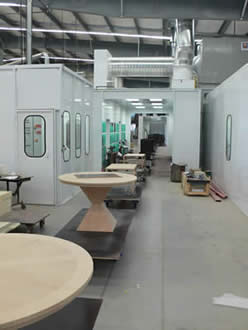 towline conveyor system carrying wooden furniture through painting line
