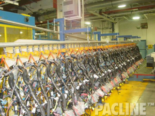 Manual trolley accumulation of automotive wiring harness. The PAC-LINE enclosed track overhead conveyor system.