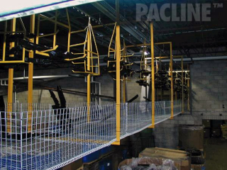Moving of automotive plastic parts between molding and assembly in building ceiling area using overhead conveyor.