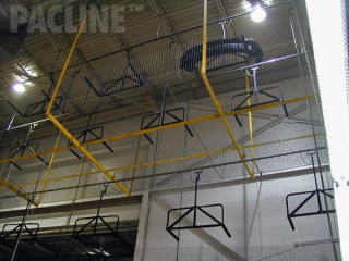 Overhead conveyor system transporting automotive fascia from molding machines to shipping using overhead space.