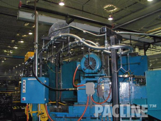 Transport of machined automotive parts between machining process using overhead conveyor system with tight curves.