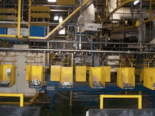Buffer accumulation and delivery of head rest support rods for automotive seats using overhead conveyor system.